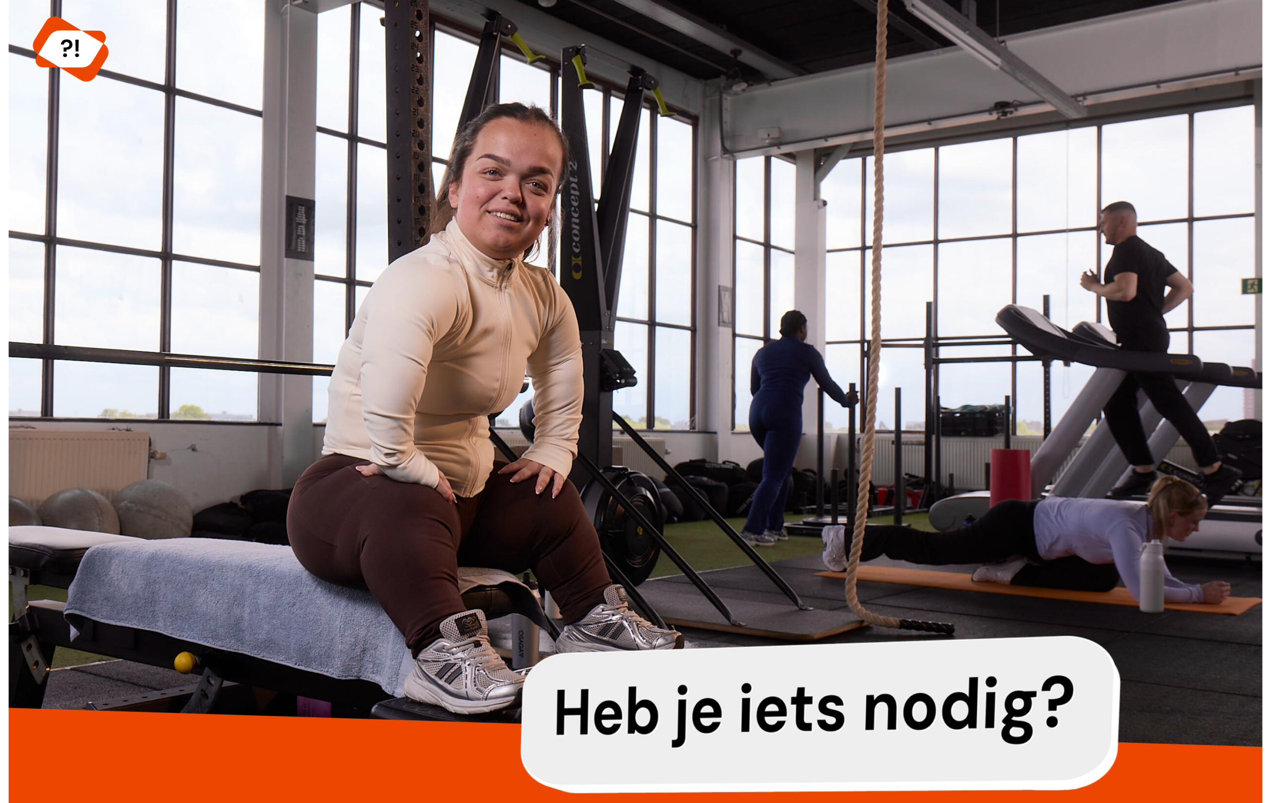 Foto van een jonge dame zittend op een fitnessaparaat, ze kijkt vriendelijk de camera in.